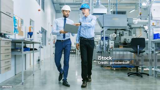 engineer di lokasi berdiskusi tentang versi drawing dan file proyek CNC